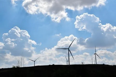 Wind turbines in a cloudy sky. Stock Photos