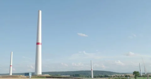 Wind turbines in construction at wide open farmland landscape panning shot Stock Footage 313034220