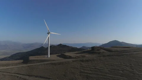 Wind turbines create renewable energy Cooling tower of power plant in background Stock Footage 87033519