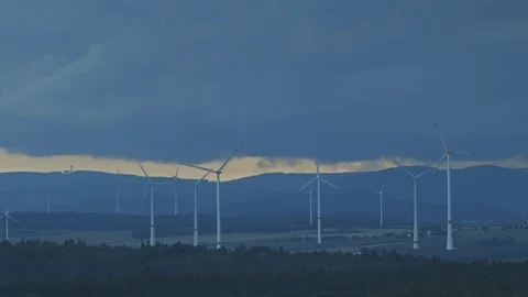 Wind turbines at dusk with storm in background Stock Footage 74631079