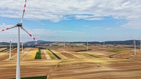 Wind turbines in fields under a clear sky during the day in a rural area near Stock Footage 342730822