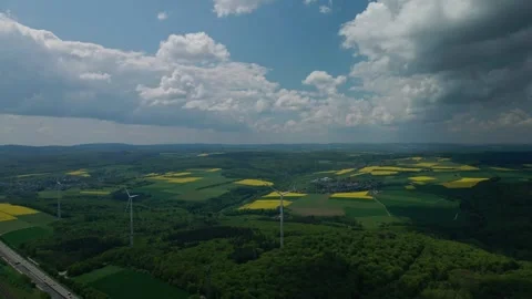 Wind turbines with fields of yellow flowers and clouds 60fr. Video stock 241232290