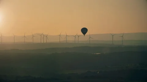 Wind turbines on flat landscape with an hot air balloon in the foreground aer Stock Footage 123870391