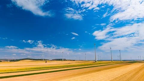 Wind turbines on a flat landscape under a clear blue sky. Wind turbines sta.. Stock Photos