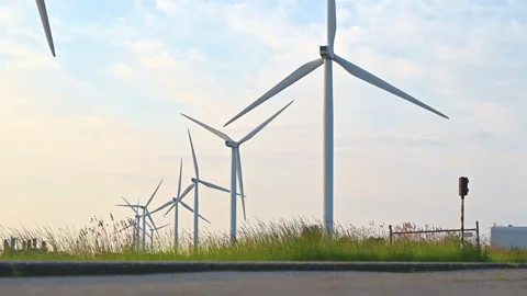 Wind turbines generate electricity  Wind turbine farm and blue sky background Stock Footage 241696248