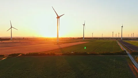 Wind turbines generate energy during sunset in a vast field Stock Footage 344263526