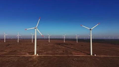 Wind turbines generate power in an open landscape near sunset Stockbeeldmateriaal 336541845