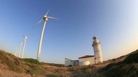 Wind turbines generating clean power with lighthouse Stock Footage 41332403