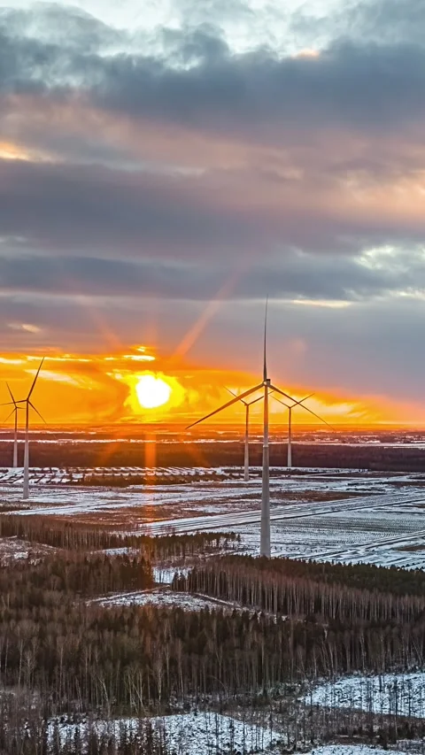 Wind turbines generating clean power across a snowy landscape during sunset 스톡 동영상 331017209
