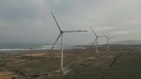 Wind turbines generating renewable energy near coastal landscape Video stock 309426007