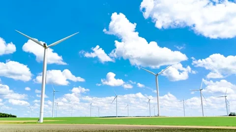 Wind turbines generating renewable energy under blue sky Stock Footage 340528996