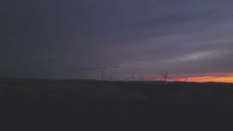 Wind Turbines Generating Renewable Energy at Sunset Over Rural Landscape Stock Footage 345110428