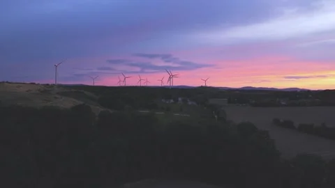 Wind Turbines Generating Renewable Energy at Sunset Over Rural Landscape Stock Footage 345110897