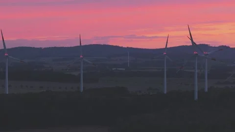 Wind Turbines Generating Renewable Energy at Sunset Over Rural Landscape Stock Footage 345111308