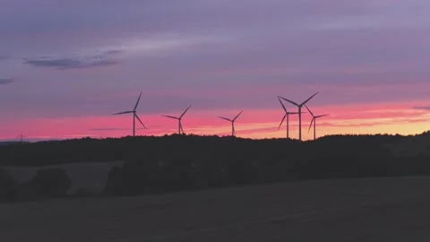 Wind Turbines Generating Renewable Energy at Sunset Over Rural Landscape Stock Footage 345111553