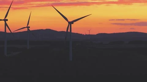 Wind Turbines Generating Renewable Energy at Sunset Over Rural Landscape Stock Footage 345112149
