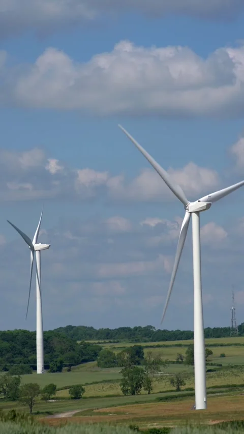 Wind turbines gracefully spin over landscape in England UK. Vídeos de archivo 277946112