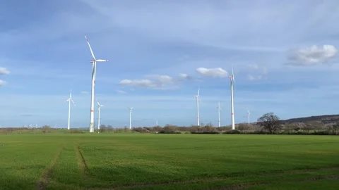 Wind Turbines on Green Field Under Blue Sky Stock Footage 337891178