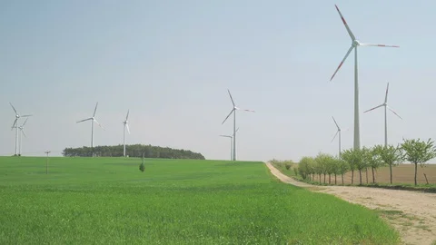 Wind turbines in the green fields in Germany. Powerful wind spinning the Stock Footage 128217519