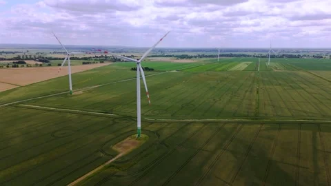 Wind turbines on green fields producing renewable energy Stock Footage 315518399