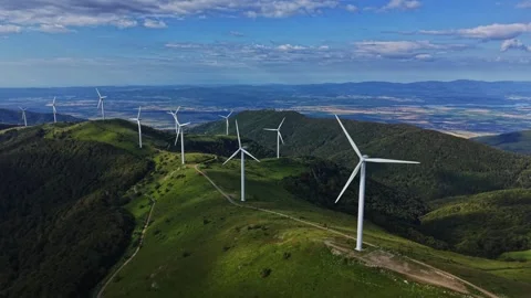 Wind turbines grow on a hillside during daylight in a large landscape Stock Footage 339161461