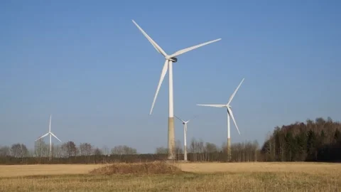 Wind turbines harness constant wind across open field. Wind delivers clean power Stock Footage 301554044