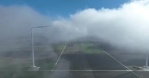Wind turbines in low hanging clouds, green wind power. sustainable energy and Stock Footage 305635815