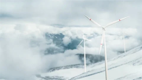 Wind turbines on a mountain pass, renewable energy. Clouds are floating, a hazy  Stock Footage 221612458