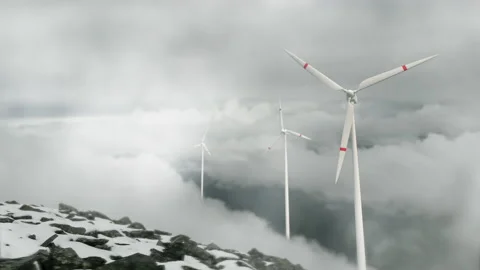 Wind turbines on a mountain pass, renewable energy. Clouds are floating, a hazy  Stock Footage 225068021