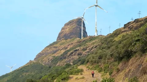 Wind turbines in the mountains, Boy walking on off road on mountain road Stock Footage 286728856