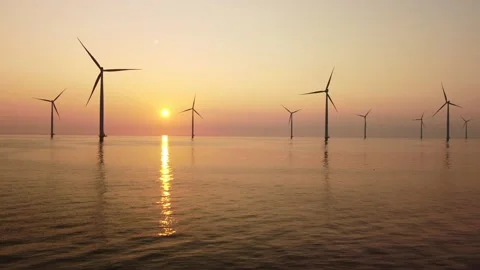 Wind turbines offshore producing electricty during sunset Stock Footage 158760809