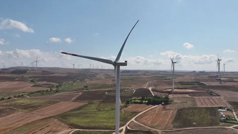 Wind turbines on open fields with a clear blue sky Stock Footage 303208794