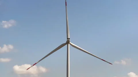 Wind turbines on open fields with a clear blue sky Stock Footage 303289114