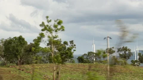 Wind turbines operate across open land with rolling hills and a cloudy horizon s Stock Footage 340890396