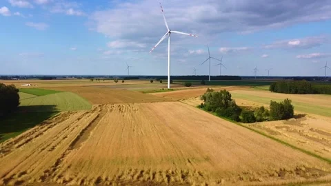 Wind turbines operating over expansive rural farmland during daytime Video stock 342591953