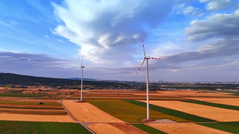 Wind turbines operating in vast agricultural fields at sunset. Wide aerial Stock Footage 339015708