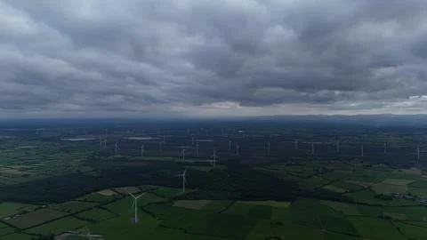 Wind Turbines Over Green Fields Under Storm Clouds Stock Photos