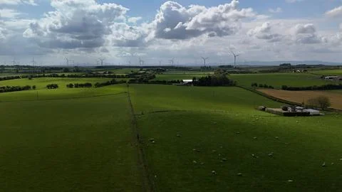 Wind Turbines Over Green Fields Under Dramatic Cloudy Sky Stock Photos