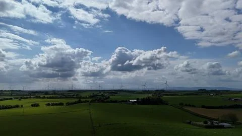 Wind Turbines Over Green Fields Under Dramatic Cloudy Sky Stock-Fotos