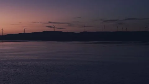 Wind Turbines over Lake at Twilight Tracking Right 4K HLG Stock Footage 343319341