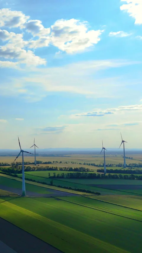 Wind turbines over patchwork fields under a partly cloudy sky. Stock Footage 318223271