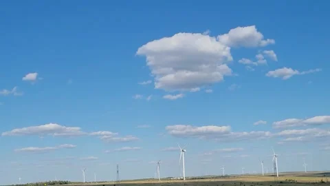 Wind Turbines Positioned Under Blue Sky Surrounded by Clouds. Wind power generat Stock Footage 290455184