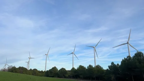 Wind turbines producing clean renewable energy on a hill Stock Footage 326789943