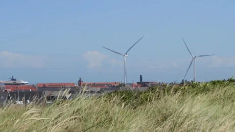 Wind turbines producing renewable energy near coastal town Stock-Footage 338329414