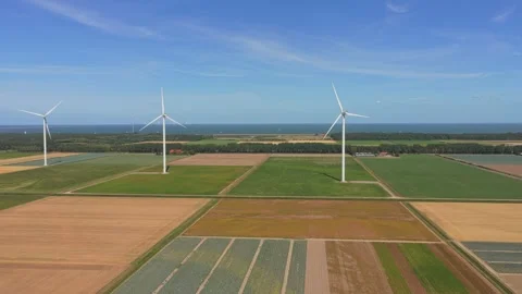 Wind turbines producing renewable energy over agricultural fields Stock Footage 342814048