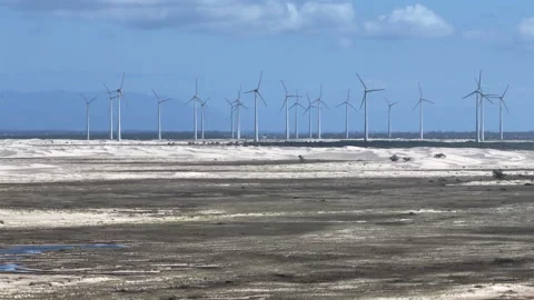 Wind turbines revealed by vertical elevator rise over coastal sand dunes Stock Footage 328500430