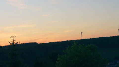 Wind Turbines on Ridge at Sunset over Forest Landscape 库存影片 338364937
