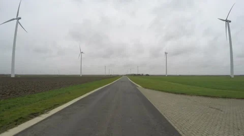Wind turbines on right left side of road driving over it in first person view 4k Stock Footage 60582437