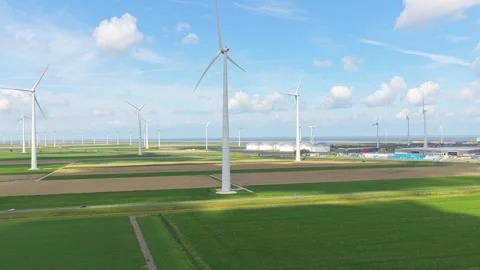 Wind turbines rising from patterned farm fields, sustainable power aerial Stock Footage 315980521