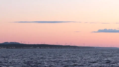 Wind turbines with the river in the foreground at sunset time with cloud Stock Footage 130862646